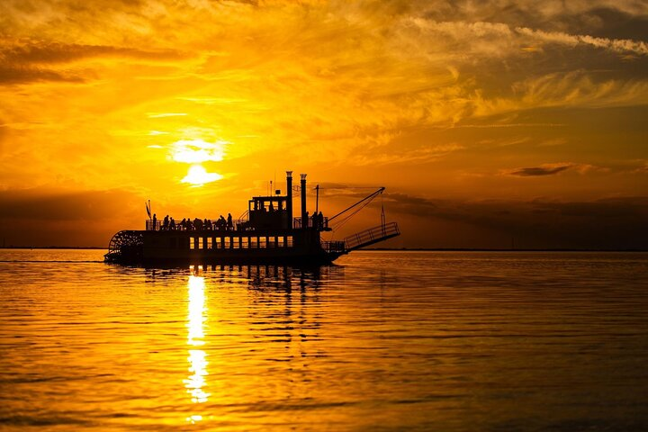 Experience the beauty of East Lake Toho as the sun sets creating a stunning backdrop for a relaxing cruise while savoring drinks and snacks with loved ones.